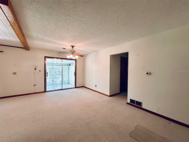 empty room with baseboards, visible vents, ceiling fan, a textured ceiling, and light carpet