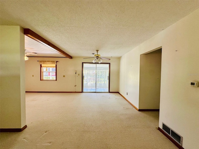 spare room with visible vents, a ceiling fan, a textured ceiling, carpet flooring, and baseboards