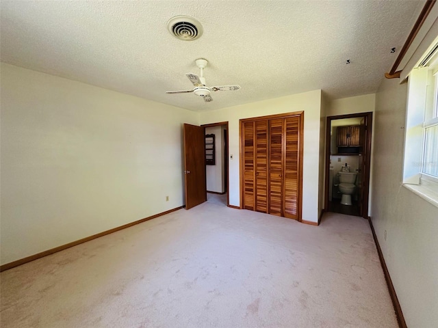 unfurnished bedroom featuring visible vents, baseboards, carpet floors, and a closet