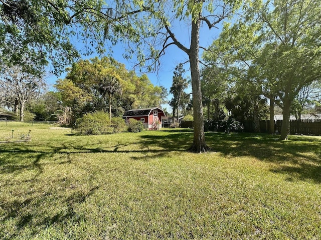 view of yard with an outdoor structure and fence