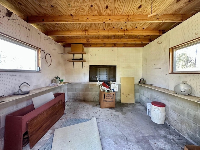 interior space with beam ceiling, concrete flooring, and wooden ceiling