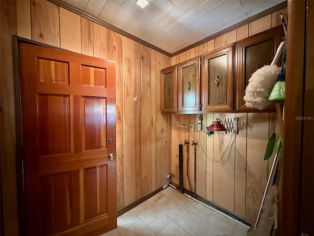 doorway to outside with wooden walls and crown molding