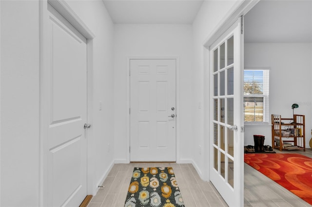 doorway to outside with french doors, baseboards, and wood finish floors