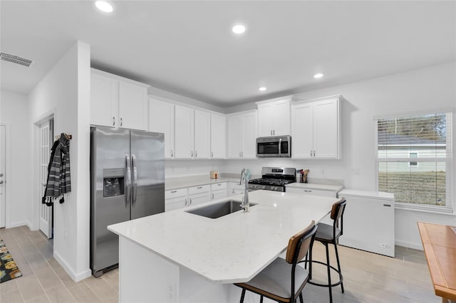 kitchen featuring visible vents, a sink, recessed lighting, stainless steel appliances, and white cabinets