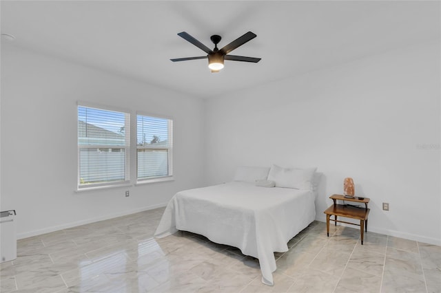 bedroom with a ceiling fan, baseboards, and marble finish floor