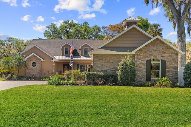 view of front of house featuring a front yard, stone siding, and roof with shingles