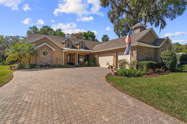 view of front of property with stone siding, an attached garage, decorative driveway, and a front lawn