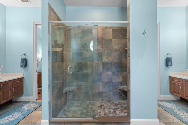 full bath with vanity, a shower stall, and baseboards