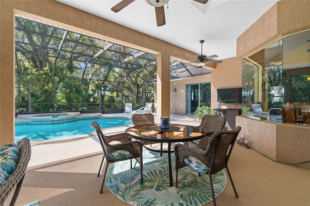 pool with glass enclosure, an in ground hot tub, a patio area, and a ceiling fan