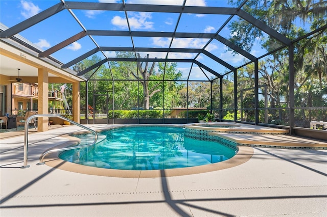 view of swimming pool featuring ceiling fan, a patio, a pool with connected hot tub, and a lanai