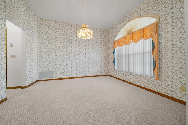 carpeted empty room featuring visible vents, baseboards, an inviting chandelier, and wallpapered walls