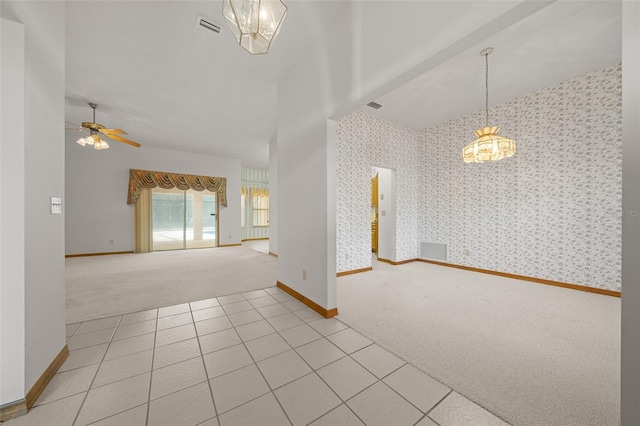 spare room featuring light tile patterned floors, visible vents, baseboards, wallpapered walls, and light colored carpet