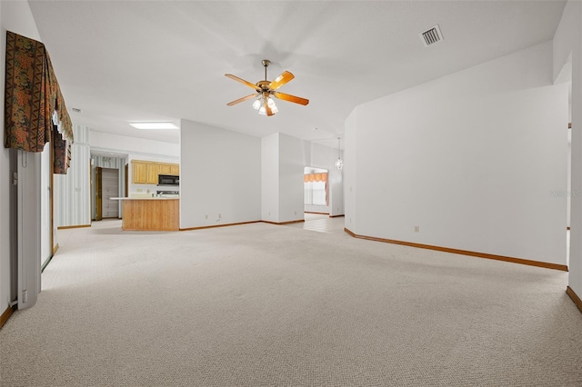 unfurnished living room with a ceiling fan, visible vents, baseboards, lofted ceiling, and light colored carpet