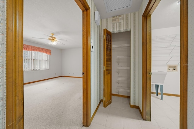 hall featuring visible vents, baseboards, and carpet floors