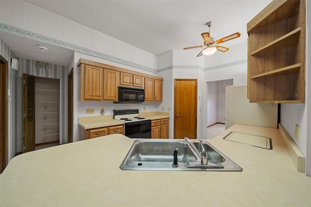 kitchen featuring freestanding refrigerator, a sink, electric range oven, light countertops, and black microwave