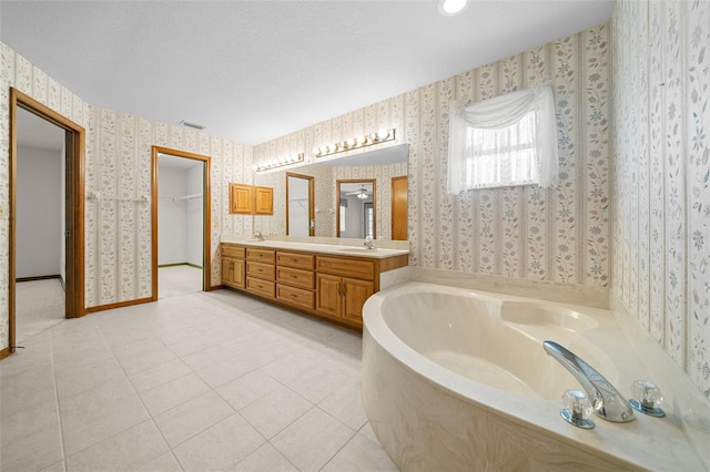 full bath with wallpapered walls, a garden tub, double vanity, tile patterned floors, and a sink