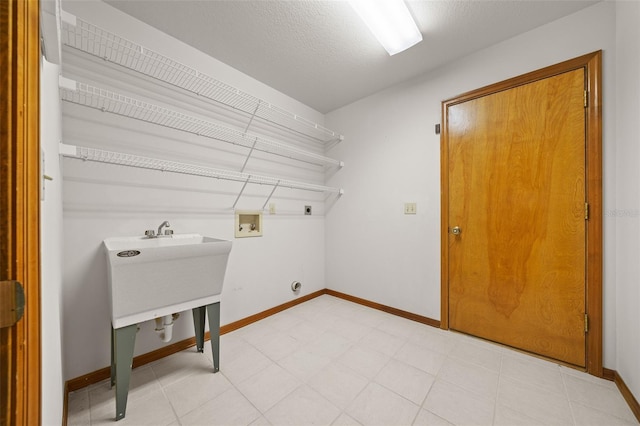 laundry room with electric dryer hookup, washer hookup, a textured ceiling, baseboards, and laundry area