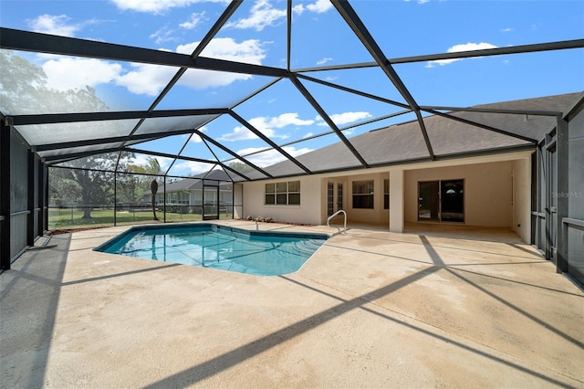 pool with glass enclosure and a patio