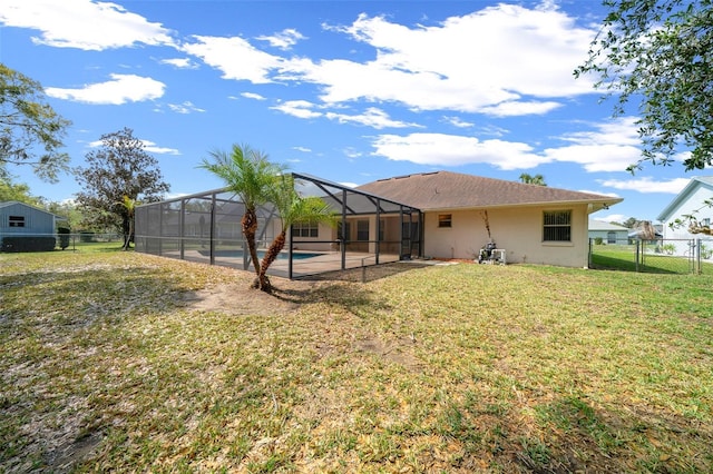 rear view of property with a fenced in pool, fence, a lanai, a lawn, and stucco siding