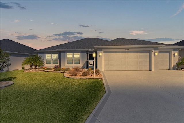 ranch-style house featuring concrete driveway, roof with shingles, stucco siding, a yard, and an attached garage