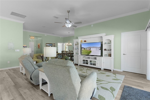 living room with visible vents, light wood finished floors, crown molding, and ceiling fan with notable chandelier