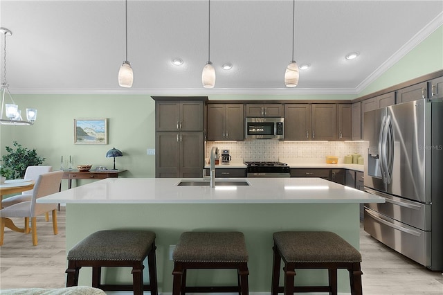 kitchen featuring a sink, ornamental molding, tasteful backsplash, and stainless steel appliances