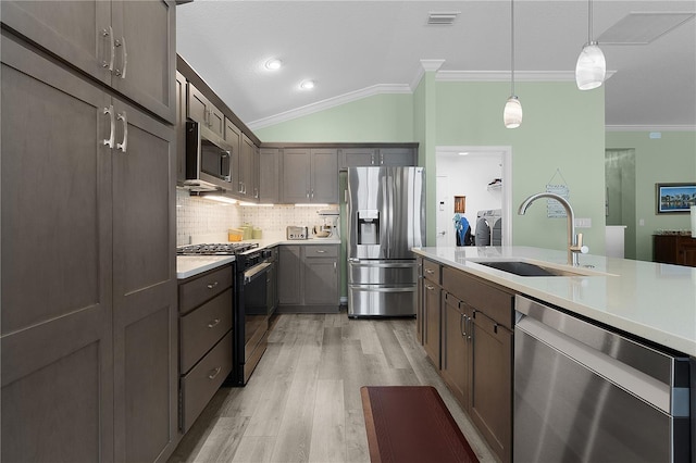 kitchen featuring visible vents, crown molding, light countertops, appliances with stainless steel finishes, and a sink