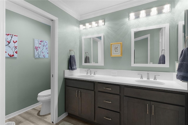 full bath featuring double vanity, ornamental molding, toilet, and a sink