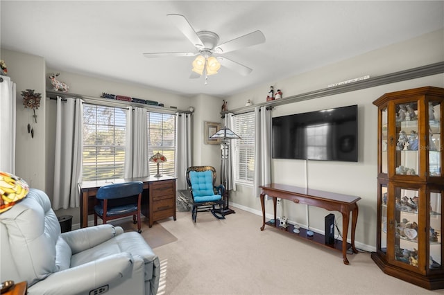 living area featuring carpet flooring, baseboards, and ceiling fan