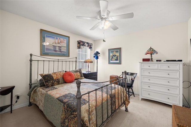 bedroom with light colored carpet, baseboards, and ceiling fan