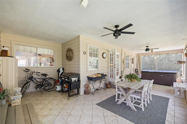 dining room with wood walls and a ceiling fan