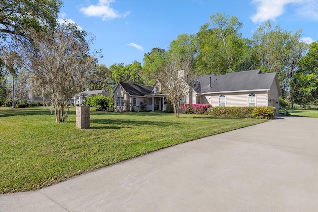 ranch-style house with a front yard and concrete driveway