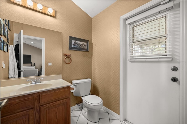 bathroom featuring vanity, tile patterned flooring, toilet, lofted ceiling, and baseboards