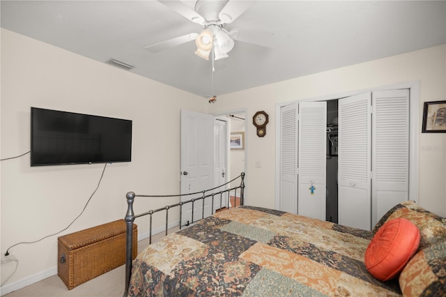 carpeted bedroom featuring a closet, visible vents, baseboards, and a ceiling fan