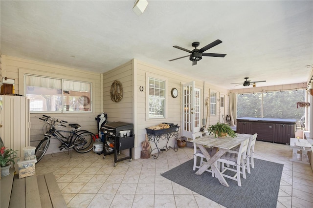 sunroom featuring ceiling fan, outdoor dining space, and a hot tub
