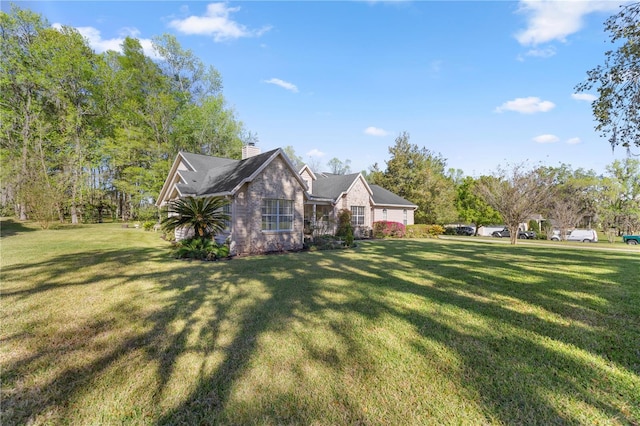 view of side of home featuring a yard and a chimney