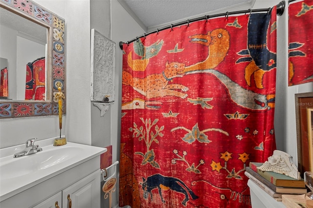 full bath featuring a shower with shower curtain, a textured ceiling, and vanity