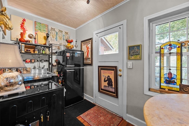 kitchen featuring baseboards, crown molding, and freestanding refrigerator