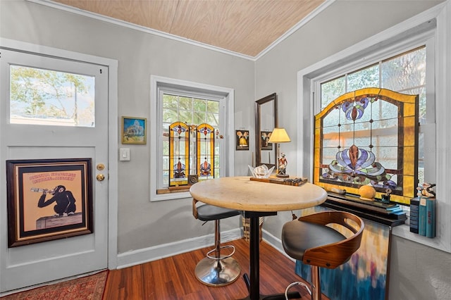 dining room featuring crown molding, baseboards, and wood finished floors