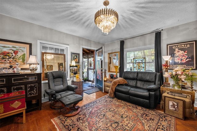 living area featuring a chandelier, a textured ceiling, and wood finished floors