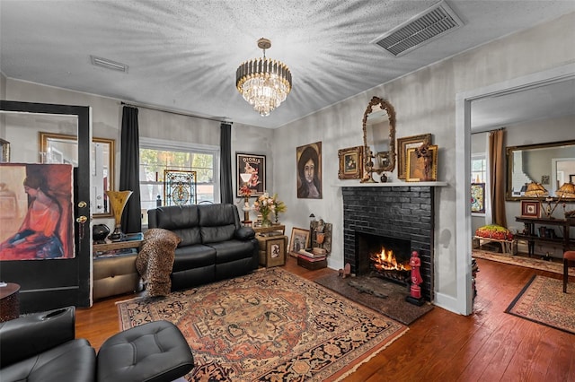 living area featuring visible vents, wood finished floors, and a fireplace