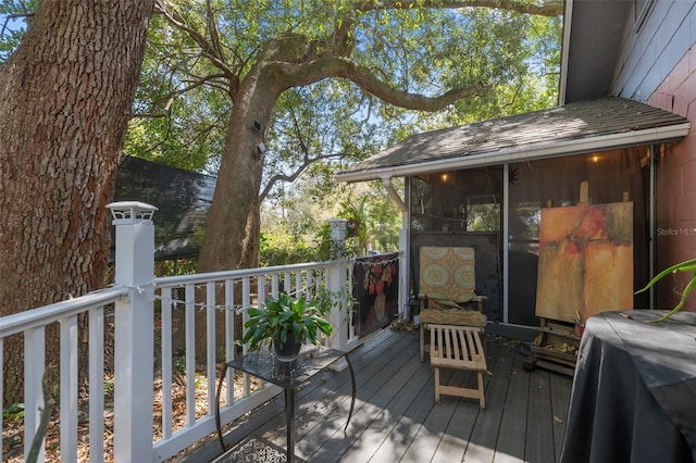 wooden deck featuring a grill and a sunroom