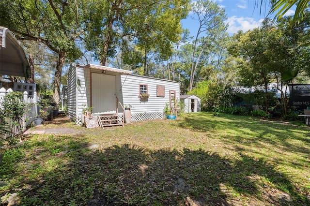 exterior space featuring entry steps, an outdoor structure, fence, and a shed