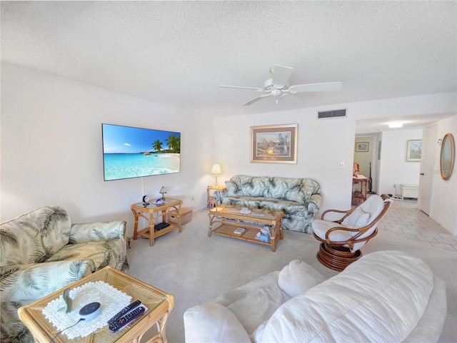 living area featuring visible vents, carpet flooring, a textured ceiling, and ceiling fan