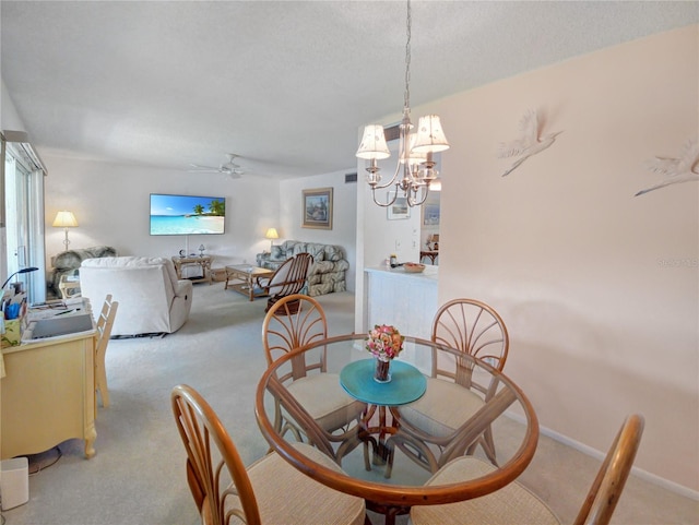 dining room with light carpet, ceiling fan with notable chandelier, and baseboards