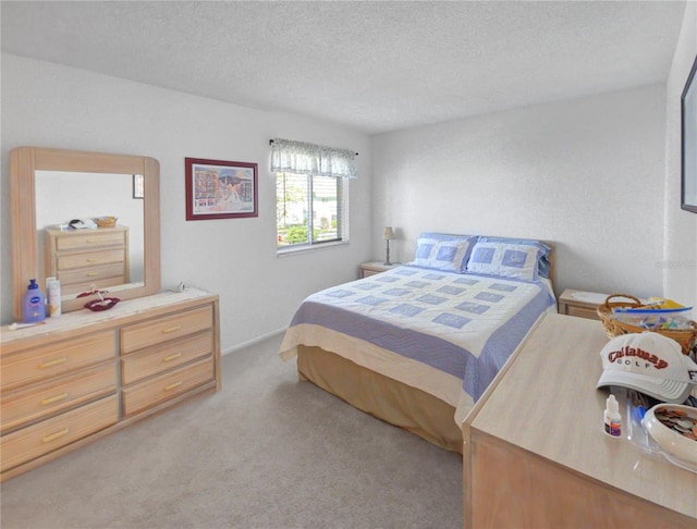 bedroom with light colored carpet and a textured ceiling