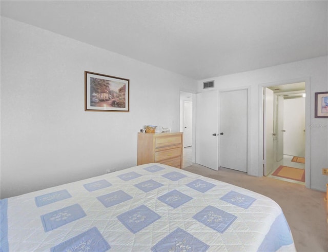 bedroom featuring visible vents, light carpet, and connected bathroom