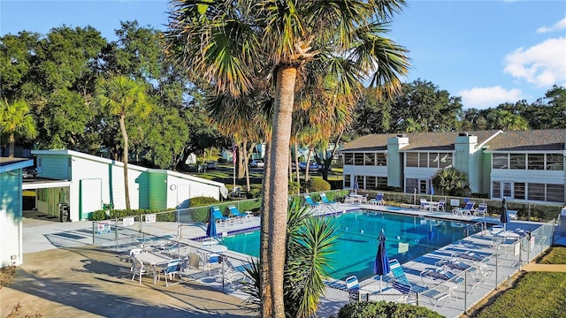 pool with a patio area and fence