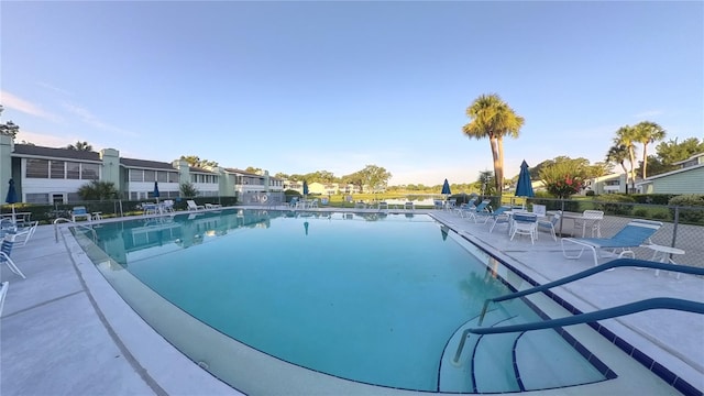 pool with a patio area and fence