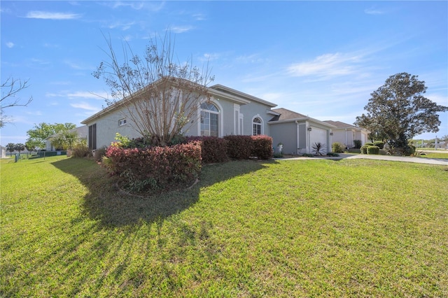 view of home's exterior featuring concrete driveway, an attached garage, a yard, and stucco siding